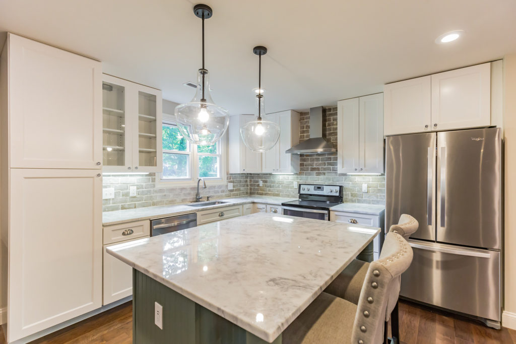 AFTER: Custom Designed Kitchen with True Reclaimed Brick Backsplash, Designer Lighting, "New Super White" Stone Counter tops, and an over-sized Island with Reclaimed Legs from an old Farmhouse Porch Column,